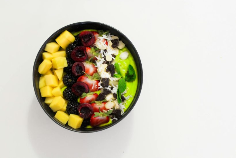 Delicious mixed fruit bowl with mango, blackberry, and cherry atop a creamy base. Perfect for a healthy diet.