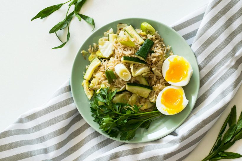 Delicious rice meal with zucchini, greens, and soft-boiled egg, perfect for a healthy diet.