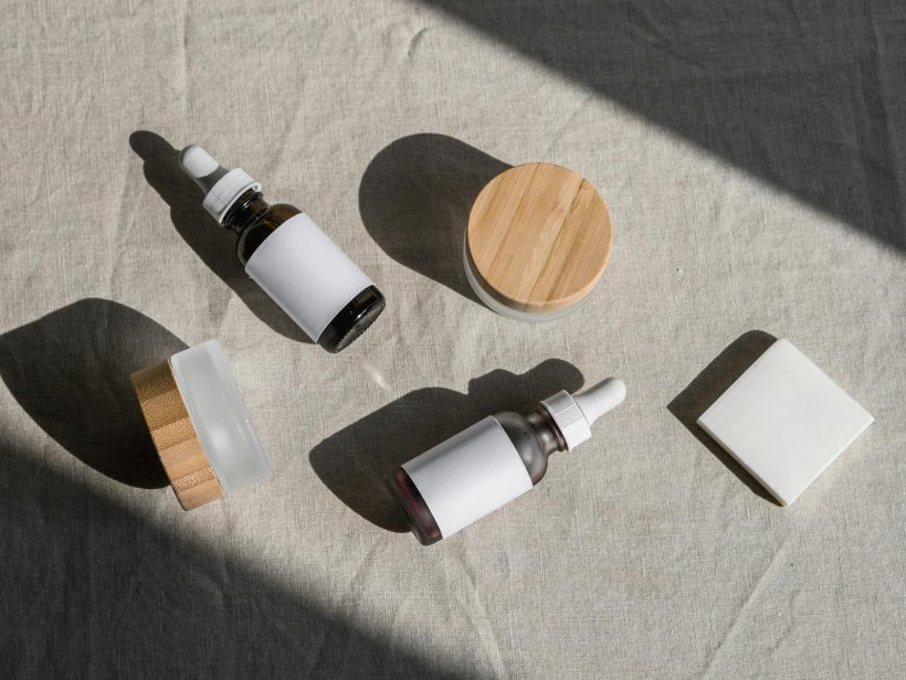 A minimalist flat lay of cosmetic bottles and jars on a linen cloth, perfect for beauty product presentations.